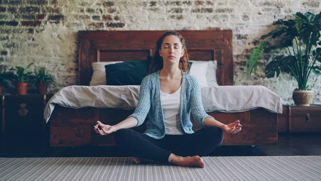 Woman meditating on the bedroom floor as an evening wind-down routine