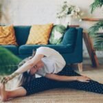 Woman doing a gentle back and leg stretch on the floor at home