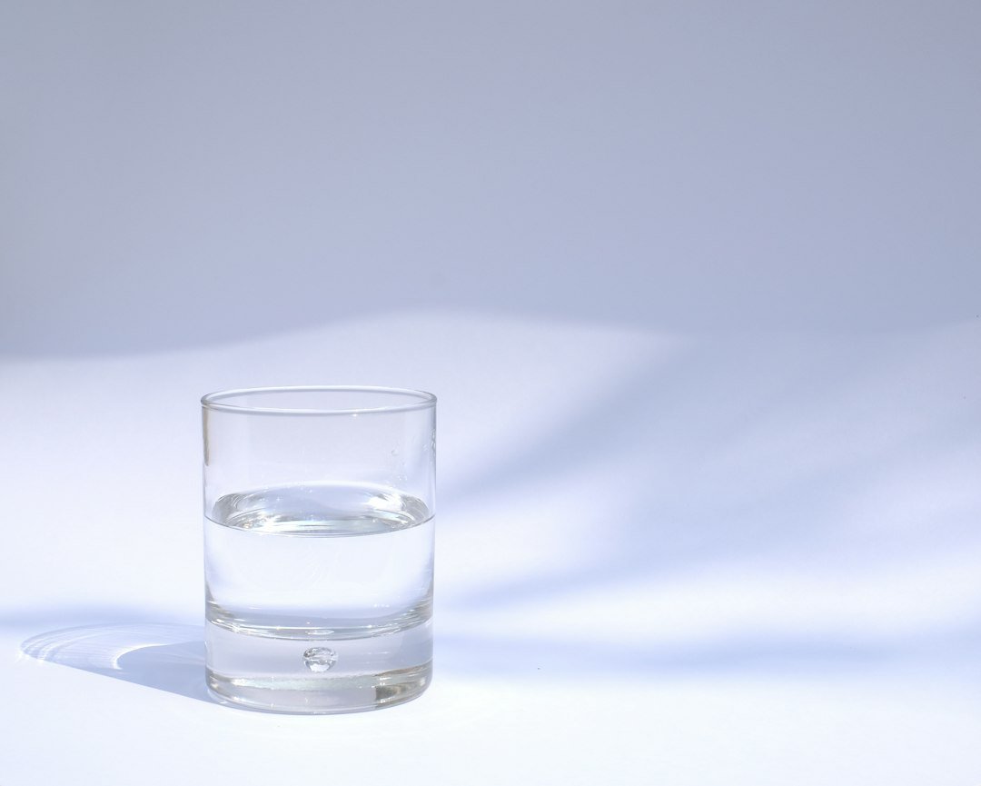 A glass of clear drinking water filled halfway