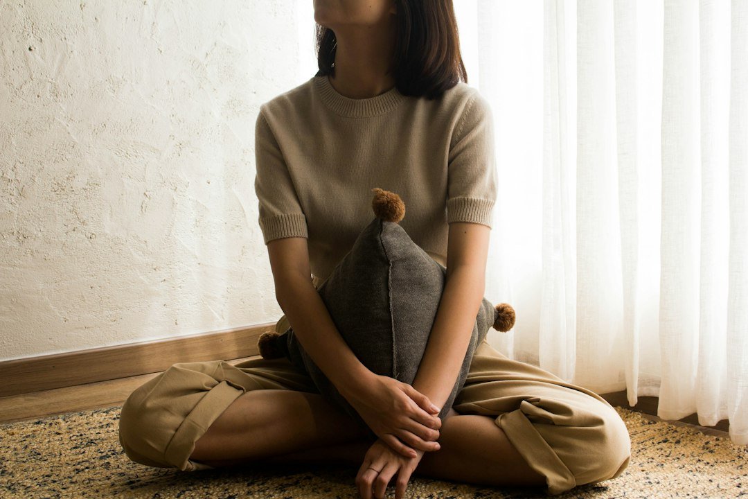 Woman sitting upright and relaxed on a wooden seat, a good posture for slow breathing exercises