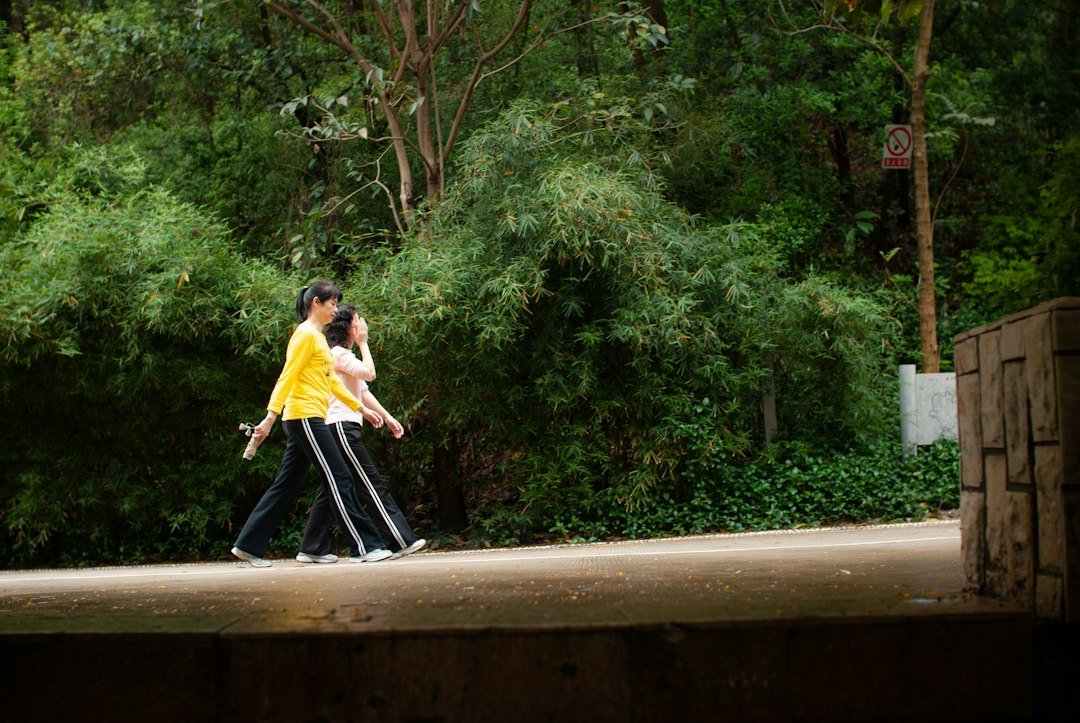 Back Pain Relief: Causes, Self-Care Tips and When to See a Doctor 3 Two people walking on a path in a park, a low-impact activity for back health